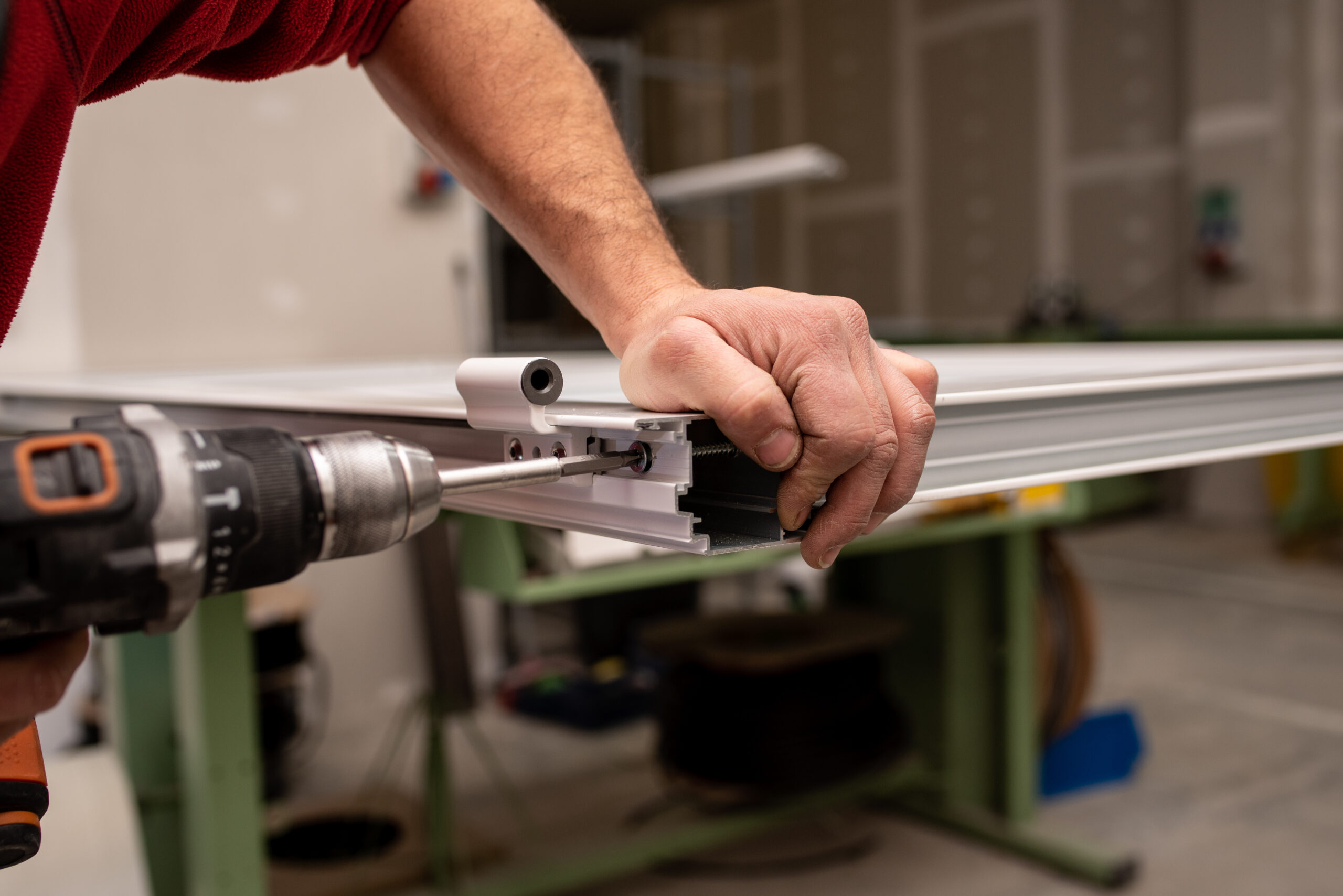 A male with a red shirt making a window with industrial tools